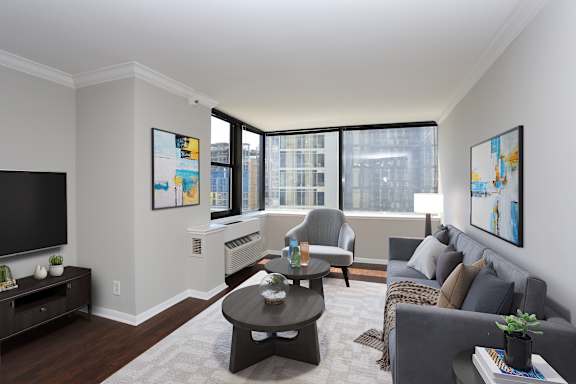 A living room with a grey couch, a black coffee table, and a flat screen TV.