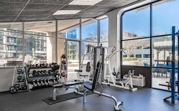 A gym with a variety of equipment including weights and machines.