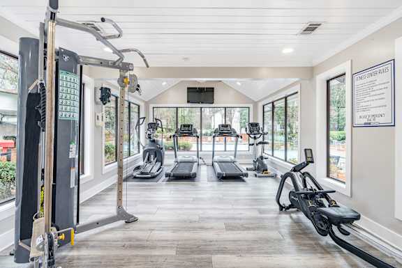 A gym with treadmills, elliptical machines, and other exercise equipment.