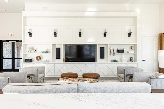 A living room with a grey sofa and a white wall.