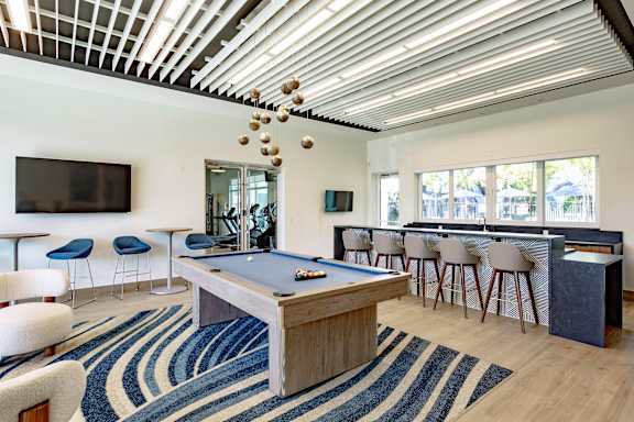 A room with a pool table and a television.
