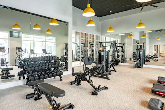 A gym with a variety of equipment including weights and machines.