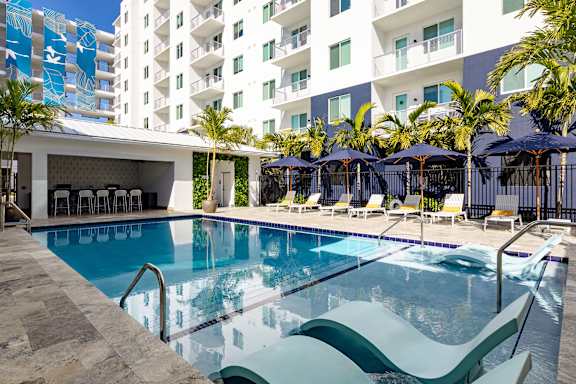 A large swimming pool with a slide and lounge chairs.