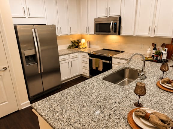 A kitchen with a granite countertop and stainless steel appliances.
