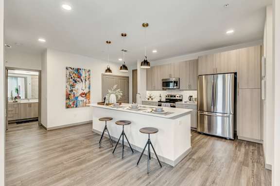 A modern kitchen with a white island and stainless steel appliances.