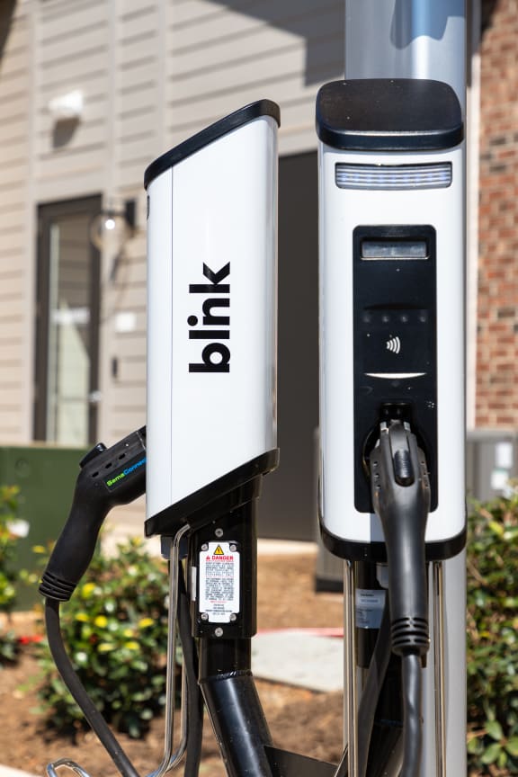 two electric car chargers on a pole at a gas station
