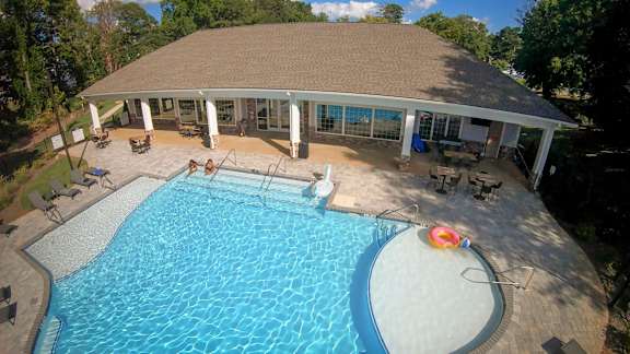 A large outdoor swimming pool with a small inflatable ring in the middle.