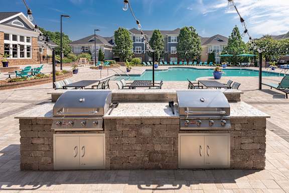 A BBQ grill is built into a brick wall.