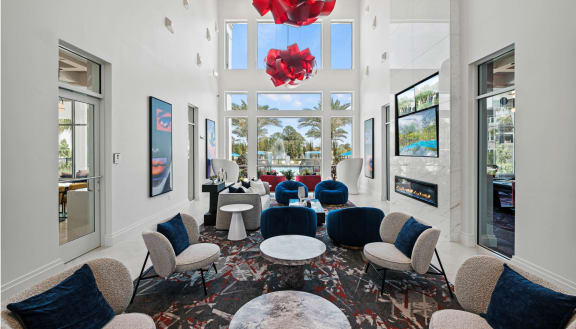 a lounge area with blue chairs and tables and large windows at Altis Grand Lake Willis, Orlando Florida