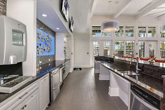A modern kitchen with a long counter and a dishwasher.