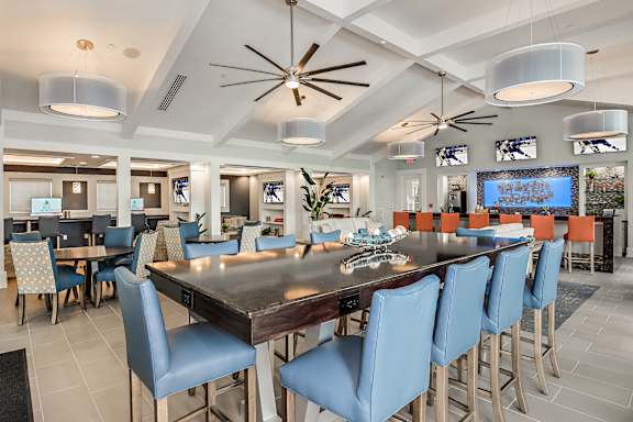 A large dining room with a long table and blue chairs.