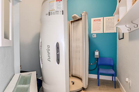 A room with a Sunfire branded water heater and a blue chair.