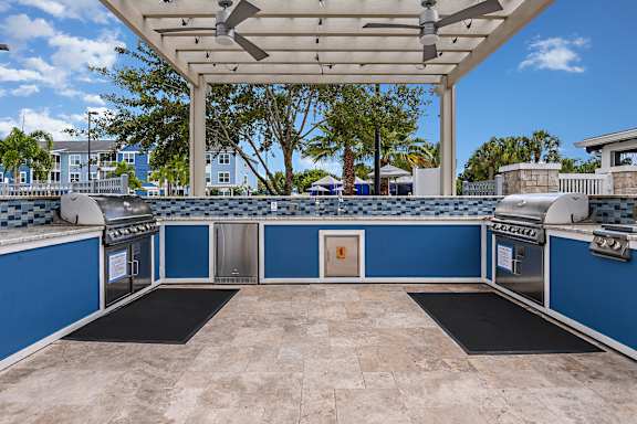 A blue and white outdoor kitchen with a grill and oven.