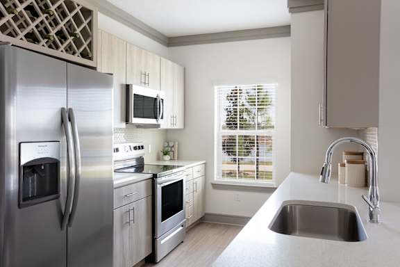 A modern kitchen with a stainless steel refrigerator and a microwave above the stove.