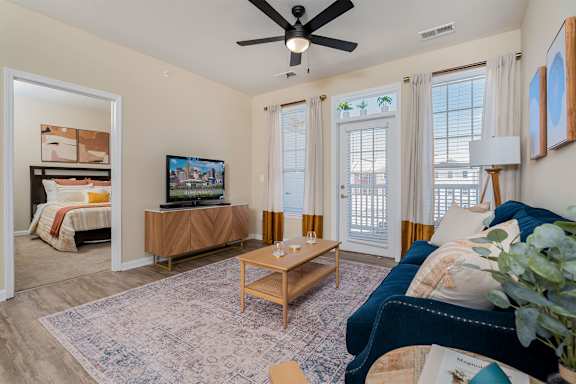A living room with a ceiling fan and a television.