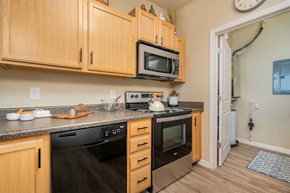 A kitchen with wooden cabinets and a black stove top oven.