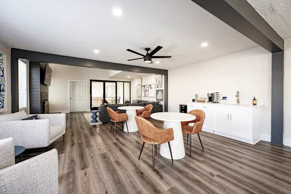 A modern living room with a dining area and a kitchen in the background.