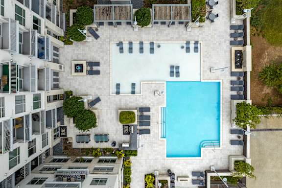A swimming pool is surrounded by apartment buildings.