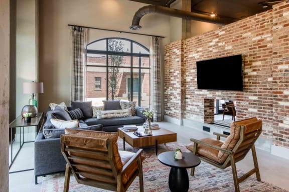 a living room with a brick wall and a large window