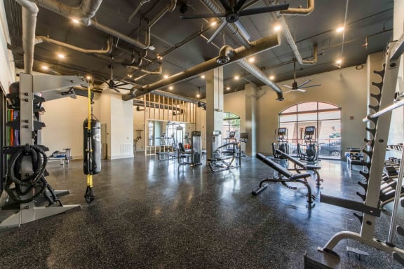 a gym with weights and cardio equipment on the floor and a glass door