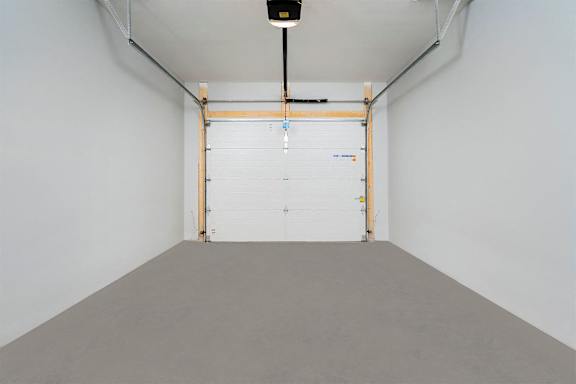 A white room with a grey floor and a white door.