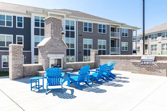 A row of blue chairs are lined up on a patio.