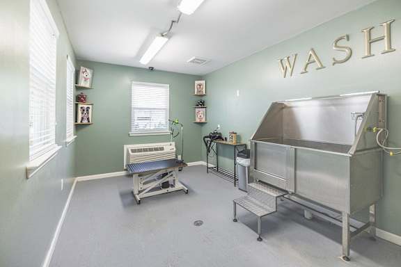 A room with a wash sign on the wall and a couple of sinks.