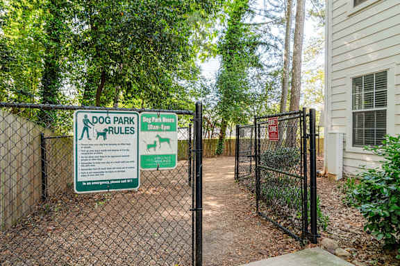 A sign for Dog Park Rules is posted on a fence.