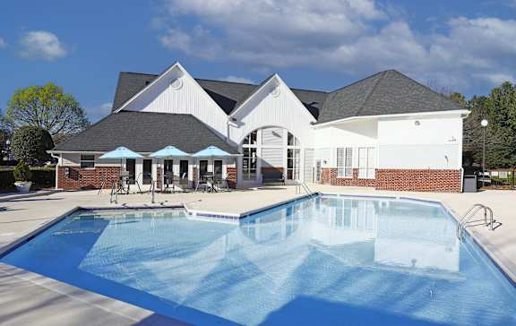 A large white house with a pool in front.