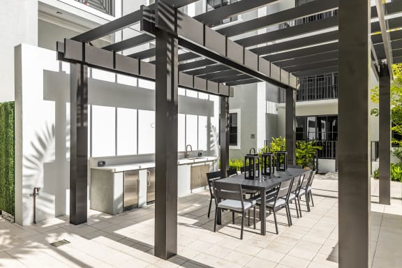 a patio with a table and chairs under a pergola at Leena Plantation, Florida, 33322