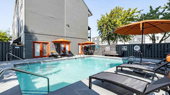 our apartments have a resort style pool with lounge chairs and umbrellas