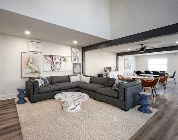 A living room with a grey sofa and a round marble table.
