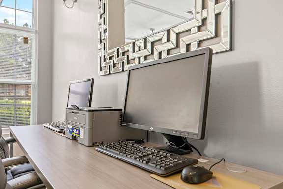 A desk with a computer, keyboard, and mouse.