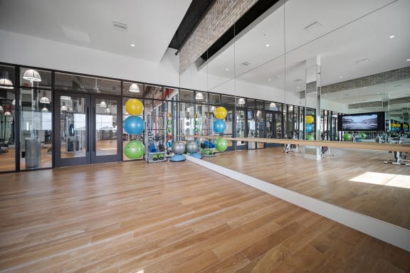 a large gym with a wooden floor and large mirrors on the wall at Altis Grand Central, Florida