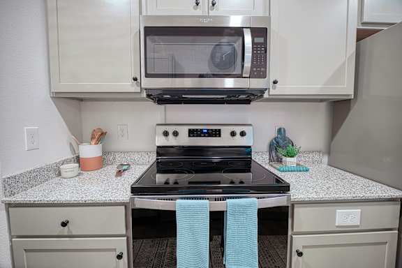 A kitchen with a stove top oven and microwave above it.