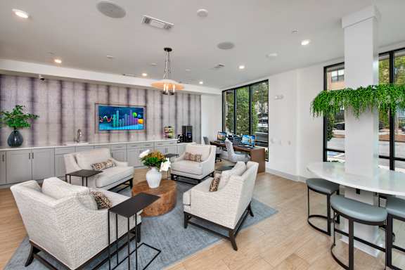 A modern living room with a large couch, a coffee table, and a TV on the wall.
