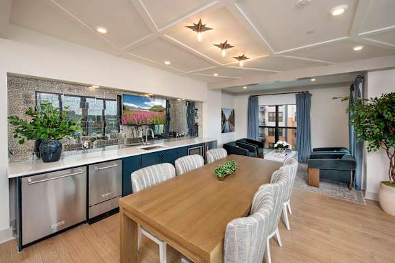 A modern kitchen with a wooden dining table and chairs.