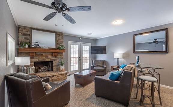 A living room with a fireplace and a ceiling fan at Winchell Way Apartment , Kalamazoo, Michigan