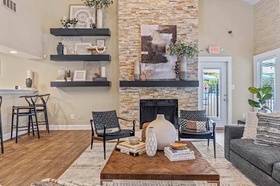 A living room with a fireplace and a stone wall.