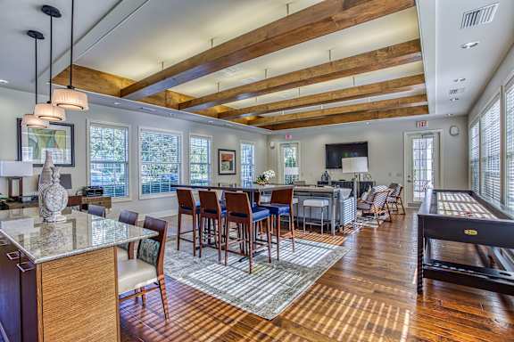 A well-lit room with wooden floors and a pool table.