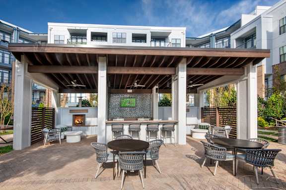 A patio with a table and chairs under a roof.