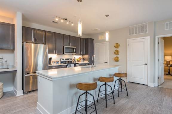 A kitchen with a white island and stools.