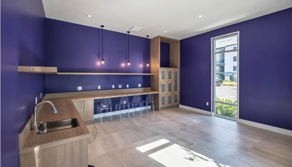 a kitchen with a purple wall and a sinkat Altis Grand Lake Willis, Orlando