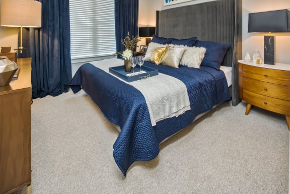 a bedroom with a bed and a dresser and window