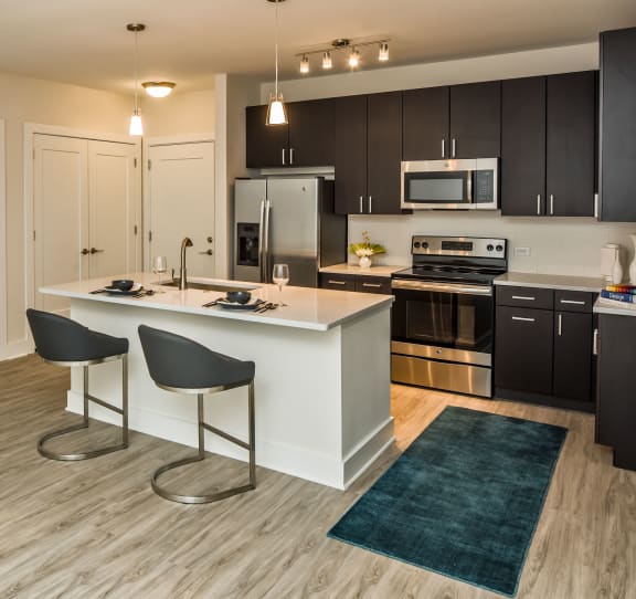 a kitchen with a white island and black cabinets