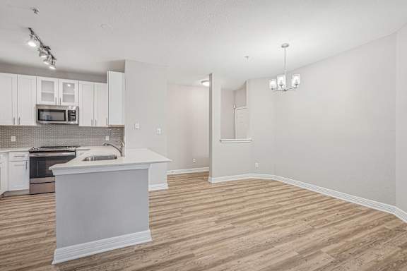 A kitchen with white cabinets and a white island.
