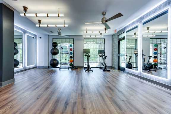 A gym with a variety of equipment including a rowing machine, a stationary bike, and a treadmill.