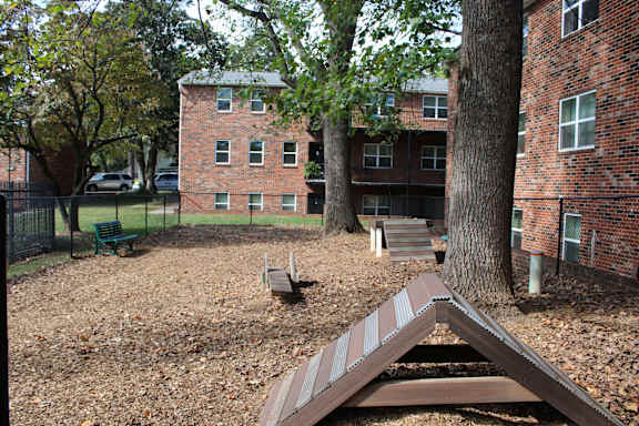 A playground with a slide in front of a brick building.