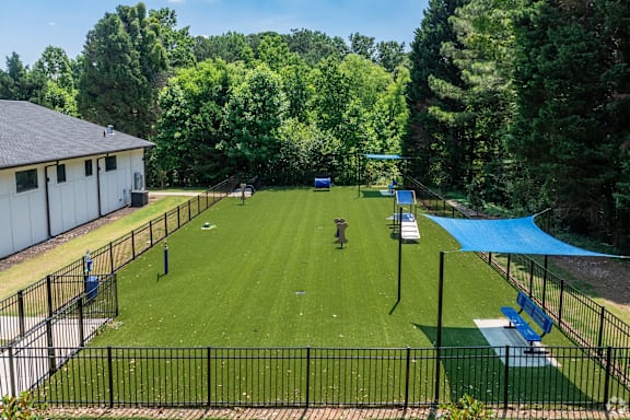 A park with a blue tarp and a black fence.