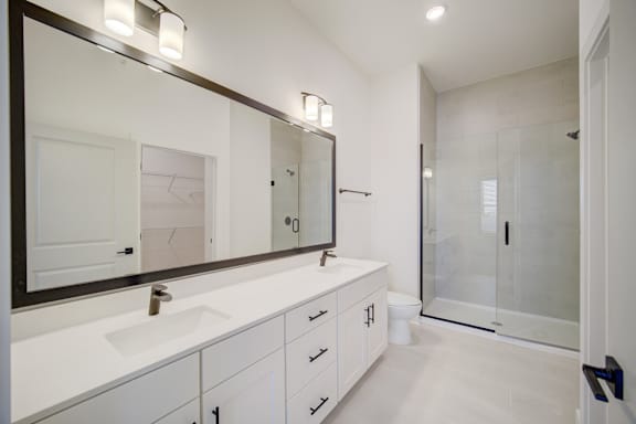 A bathroom with a white sink and a large mirror.